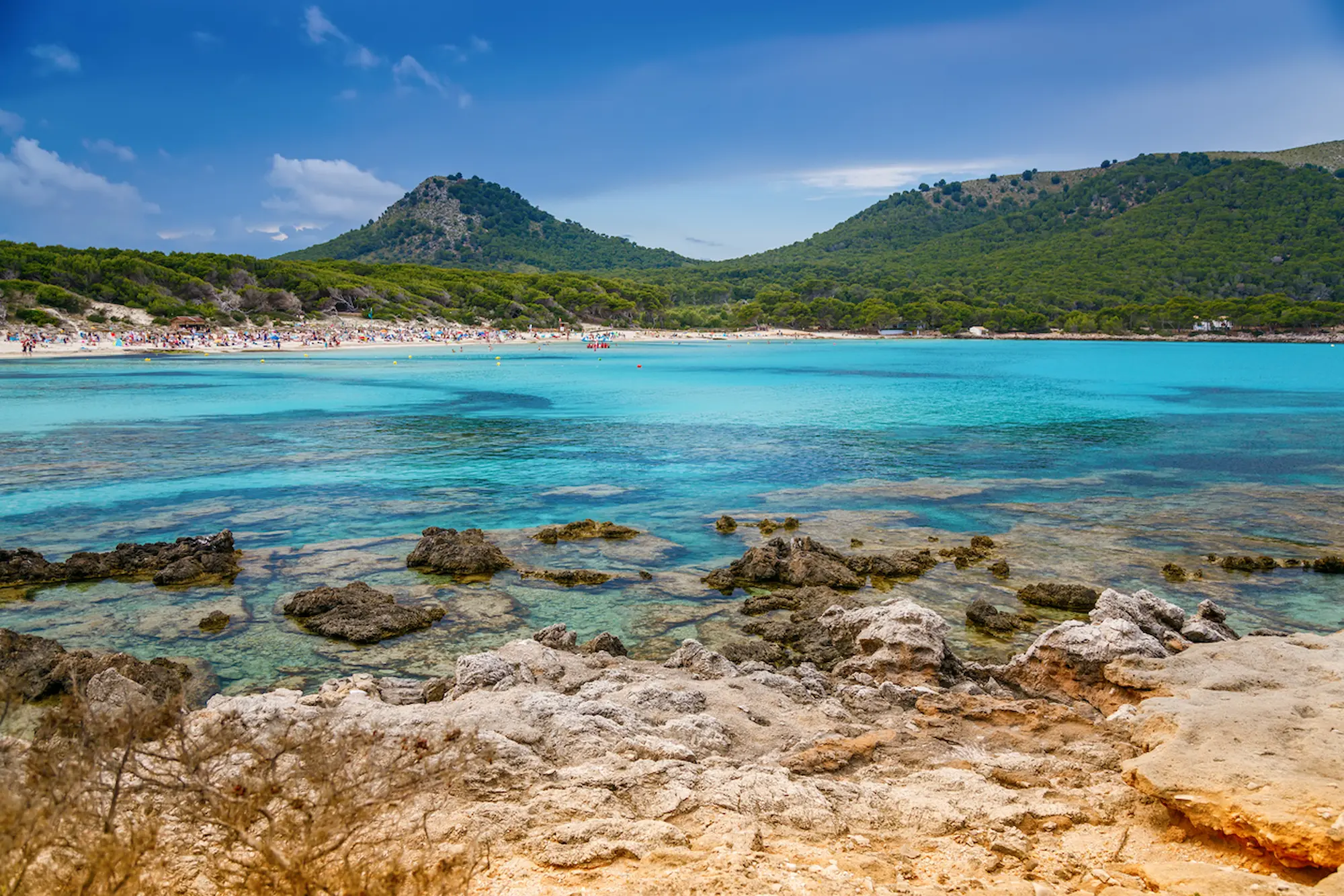 View of Cala Agulla with mountains and crystal clear water