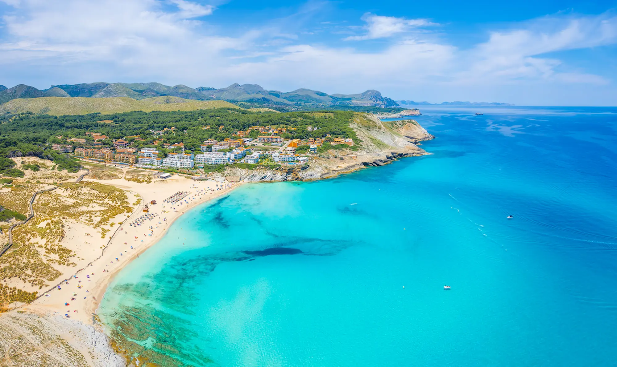 Birds eye view of Cala Mesquida's sandy beach and blue waters