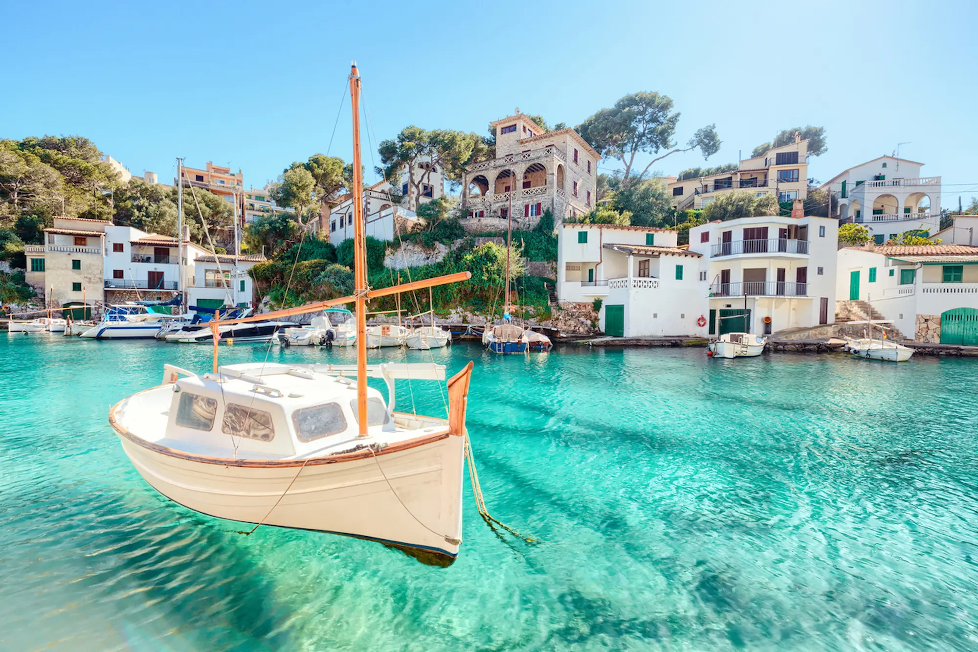 Cala Figuera's clear waters with a boat