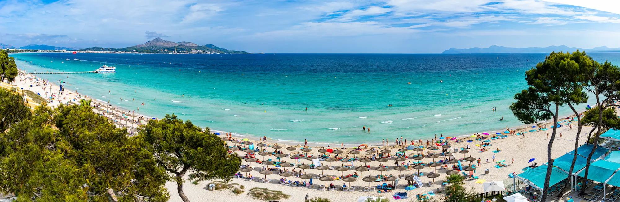 Panoramic of people on the beach and light turquoise water