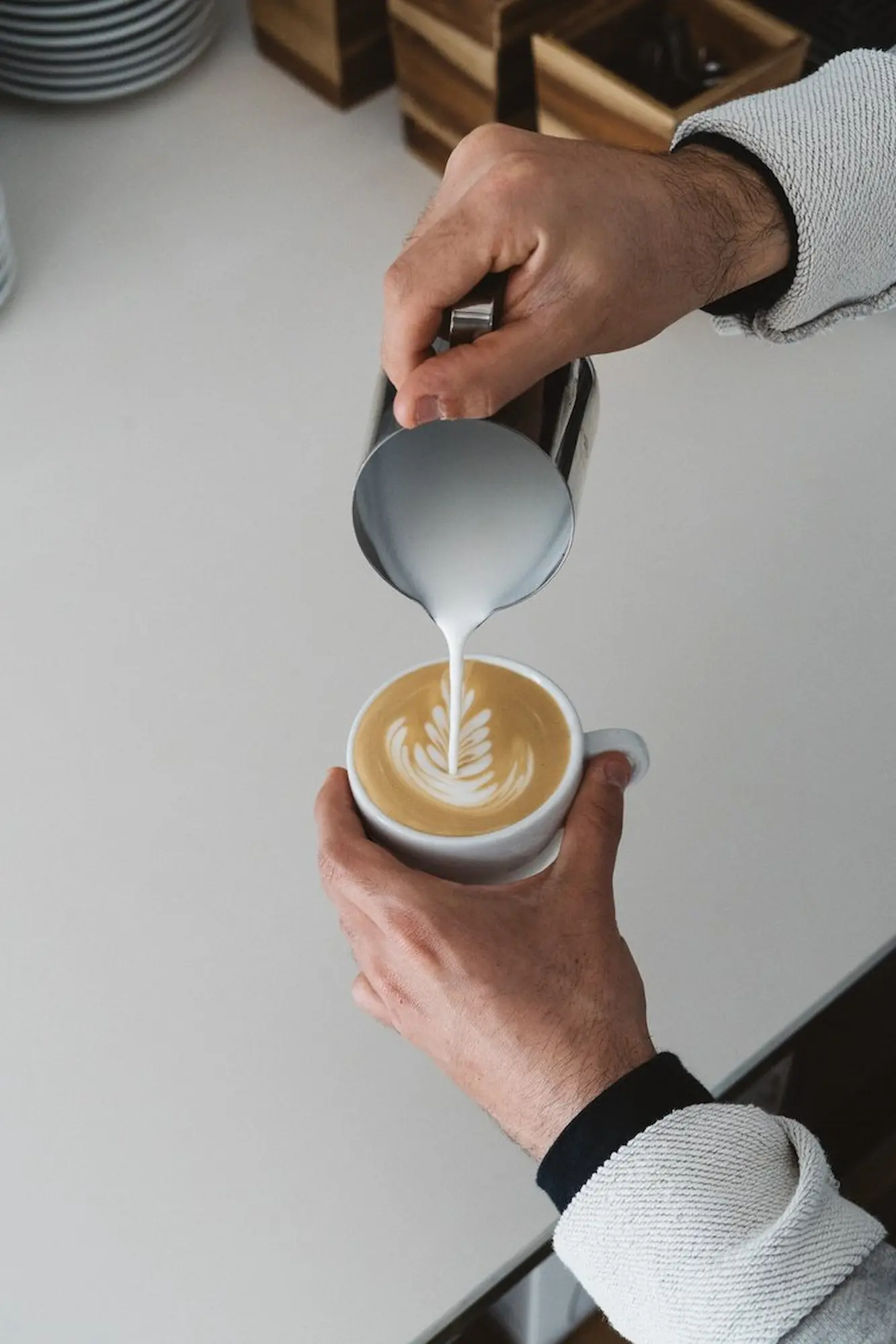 Pouring frothed milk over coffee. Courtesy La Molienda