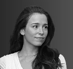 Black and white portrait of a woman with long dark hair wearing a light-colored top, looking to the side.