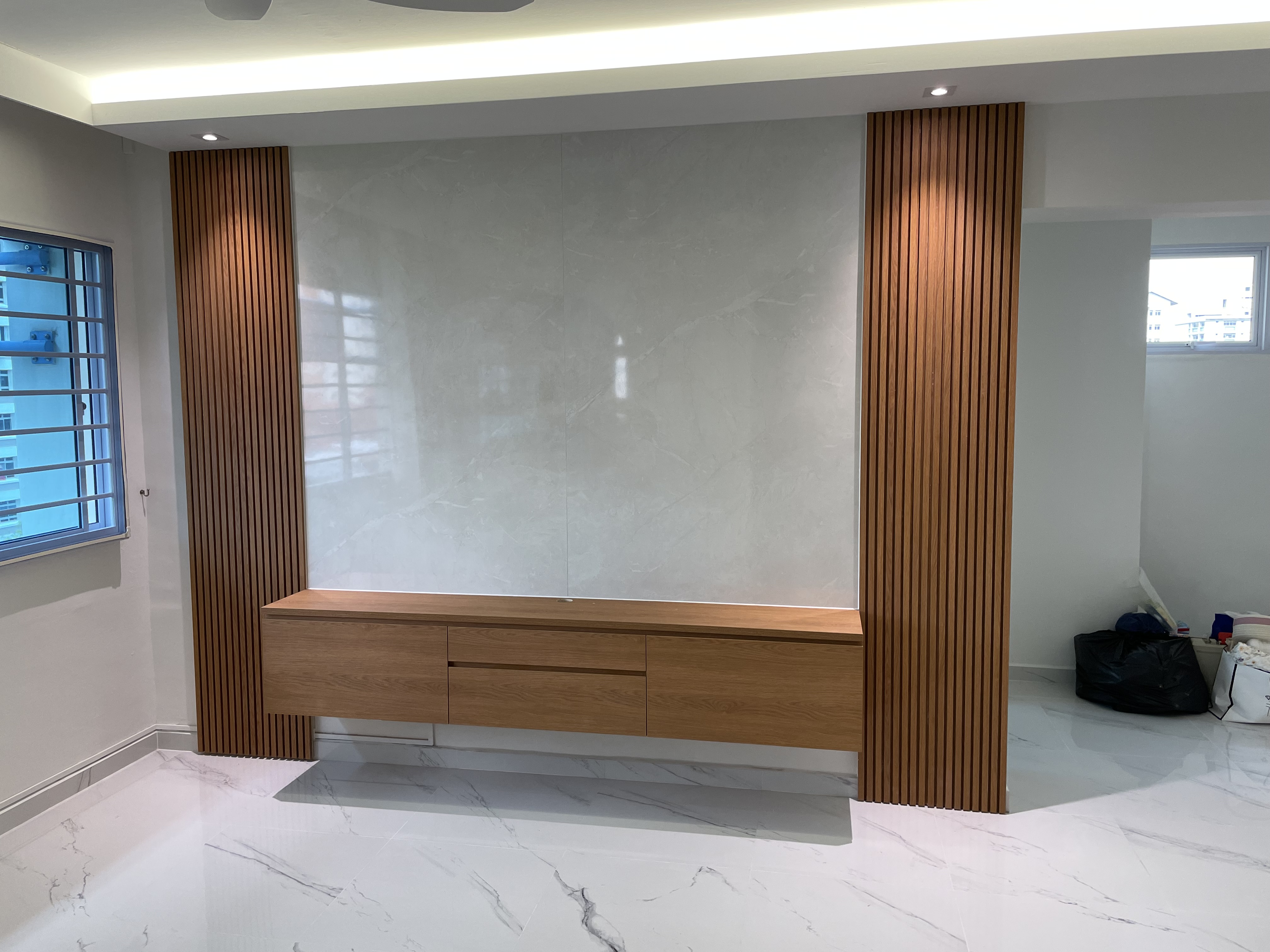 Marble finish wall feature with wooden louvre and tv console.