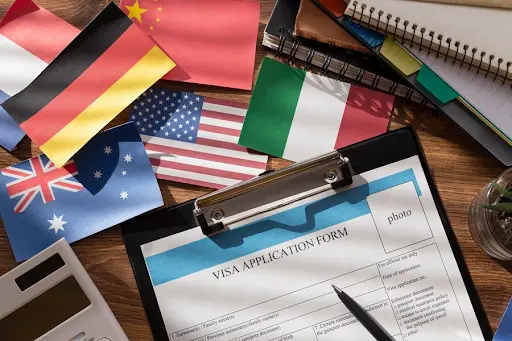 Visa application form with international flags on desk illustrating Australian business visa options in Melbourne for entrepreneurs - Legalfinda
