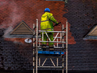 Sean cleaning a roof, photo