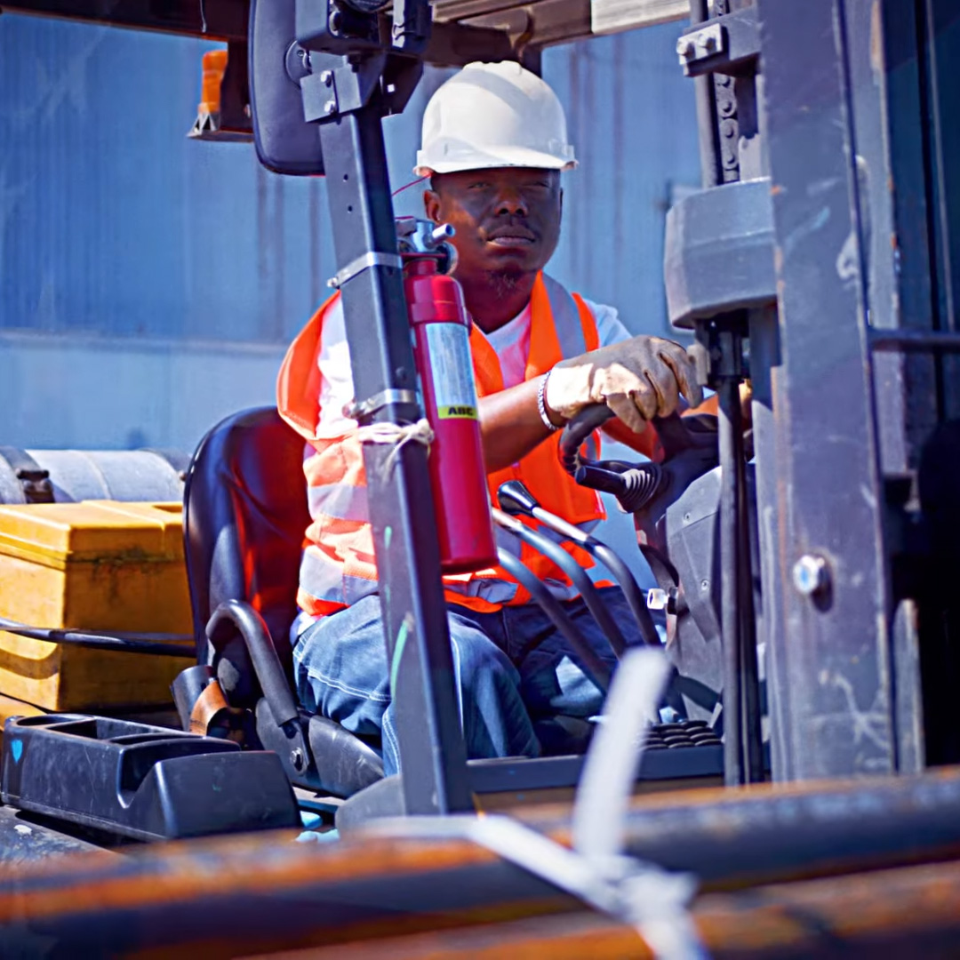 worker driving forklift at manufacturing facility