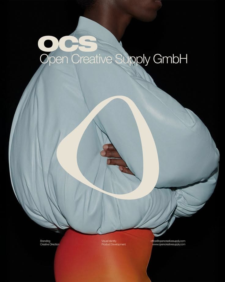 Pale blue oversized puffer garment shot on black for Open Creative Supply, marked with a white oval