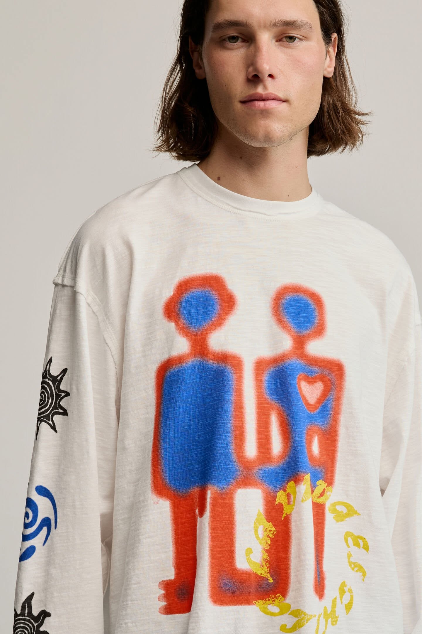 Long-sleeved T-shirt in 100% cotton knit fabric. It features a crew neck and a print of geometric shapes on the front and motifs on the sleeves. The design is white with blue and black details. Fit: RegularKnit fabricGraphic print on front and sleevesCrew neckLong sleevesMaterial: 100% cottonBase co