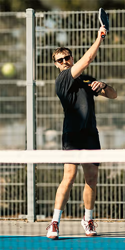 man following through with his forehand topspin serve