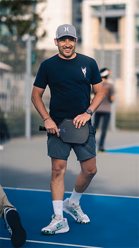 man smiling after winning a pickleball point