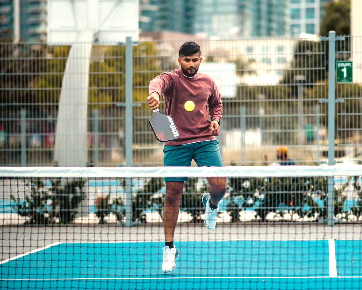 man jumping hitting a backhand volley at the kitchen