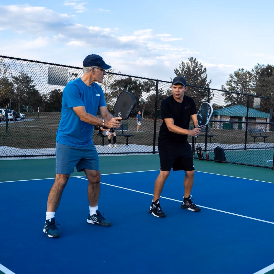 Pickleball coach demonstrating technique with a student.