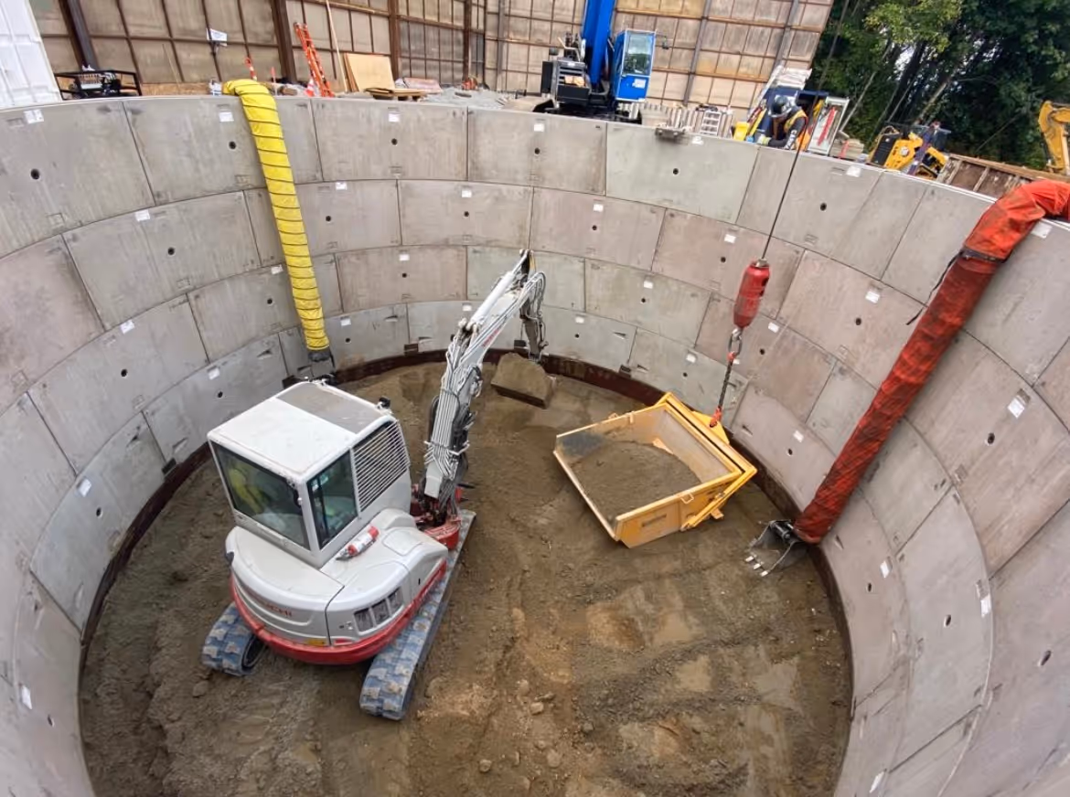 looking down into a shaft with a digger inside