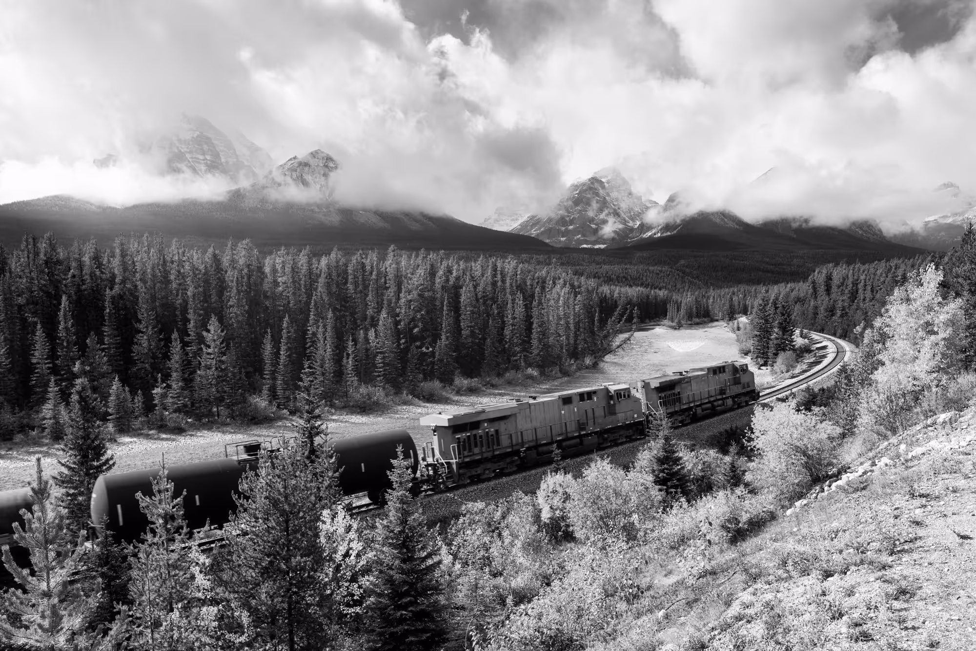 a train going through the mountains of alberta