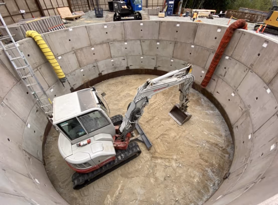 a digger is inside of a dug out shaft