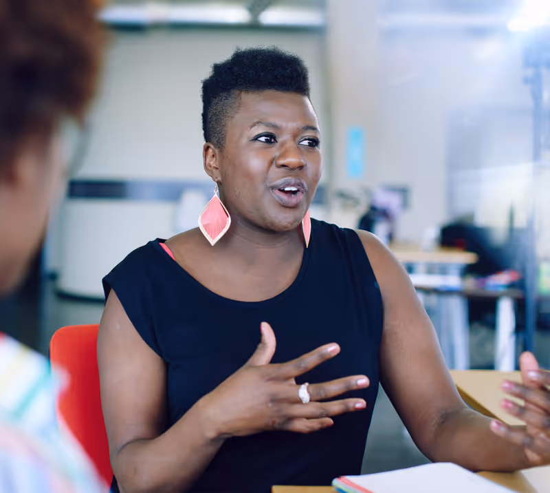 An Achieving for Children staff member having a conversation with colleagues