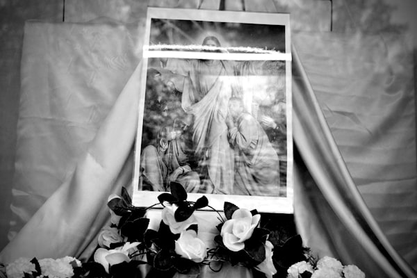 A religious picture is on display with flowers.