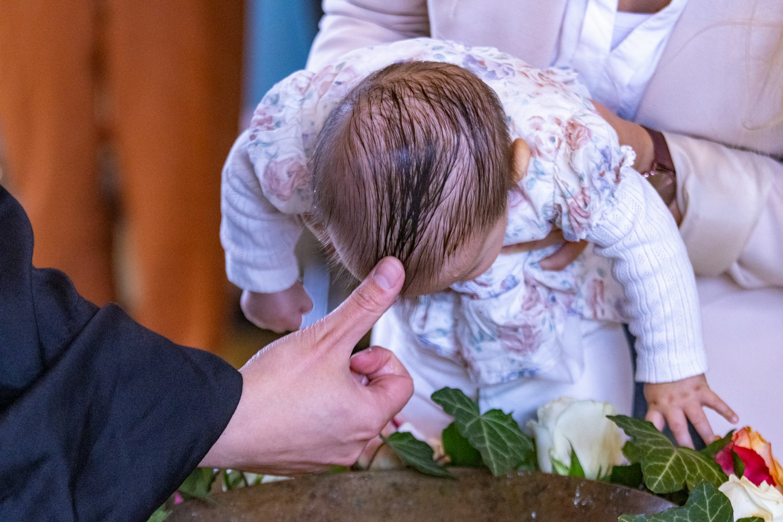 A little girl is being held up by a woman