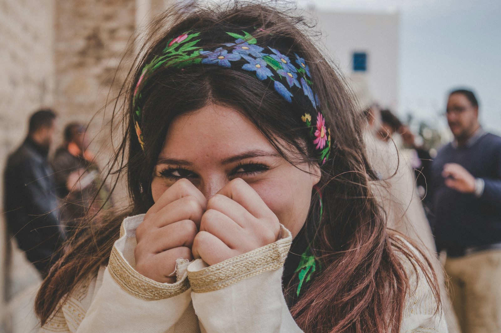 woman smiling and covering half of her face with her hands
