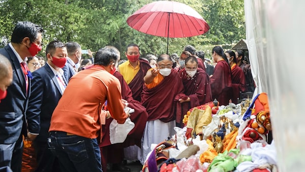 a group of people standing around a table with food and umbrella