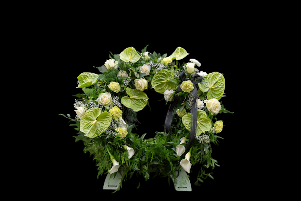 A circular floral arrangement with white and green flowers.