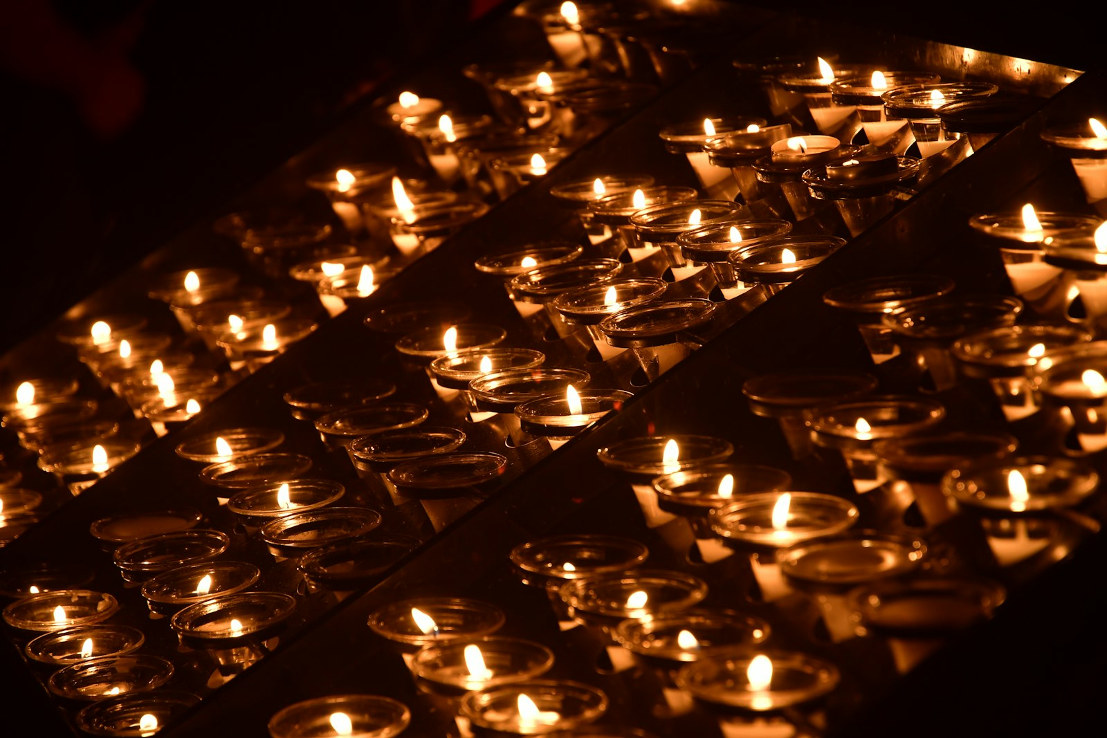 Many small candles glowing in the dark