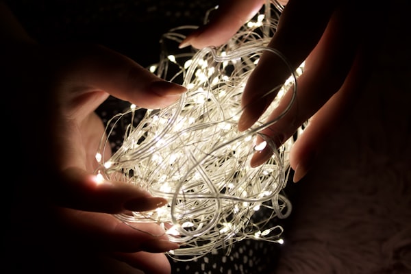 Hands holding a tangled ball of fairy lights