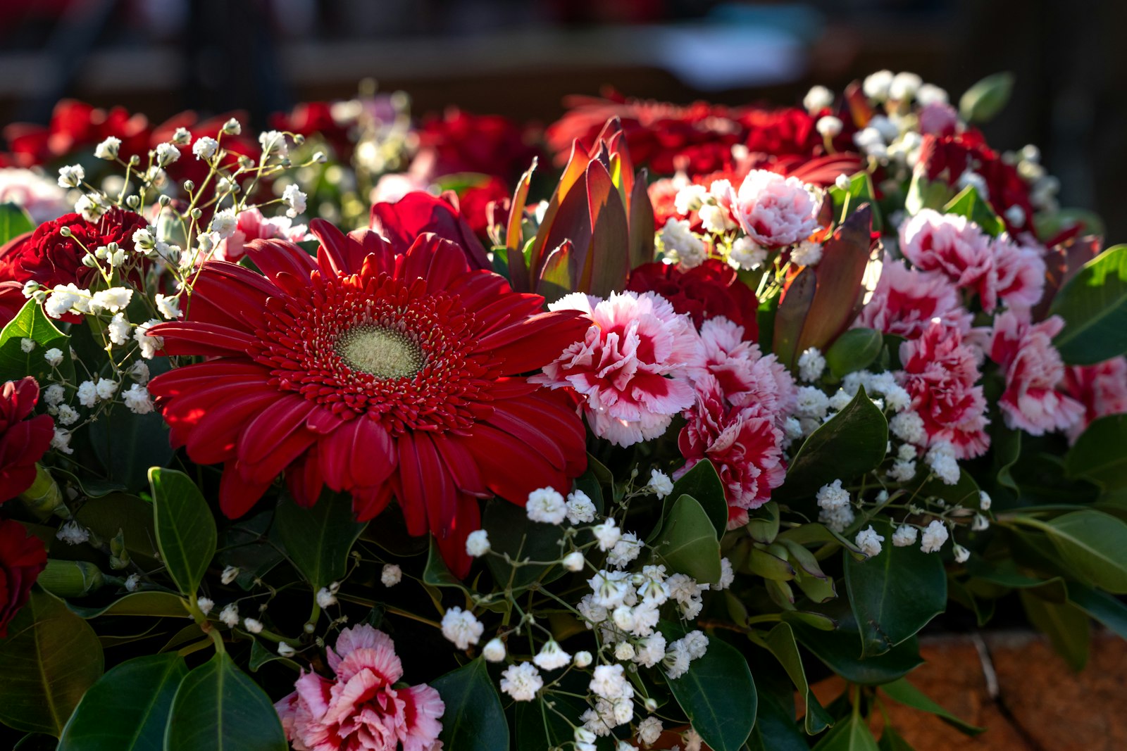 a bunch of red and white flowers sitting on top of a table