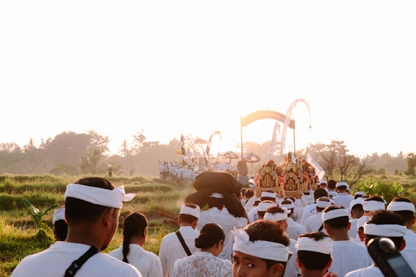 Procession of people in white attire with ornate carriage