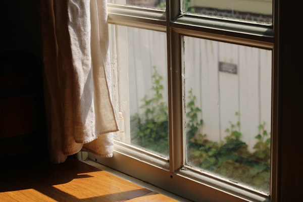 Sunlight streams through a window with a curtain
