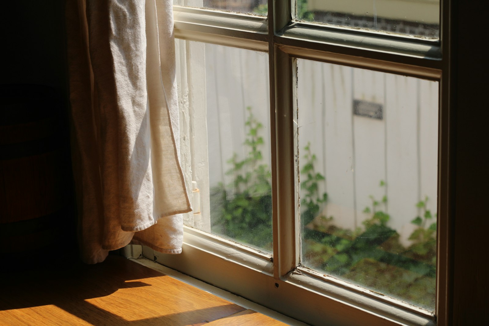 Sunlight streams through a window with a curtain