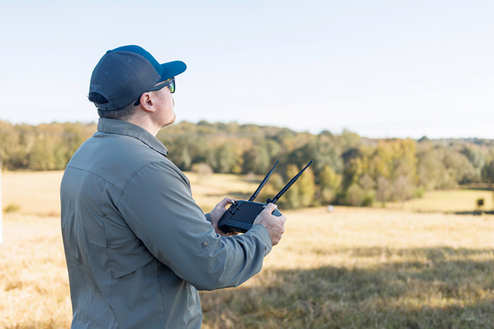 Drone operator with remote looking into the sky