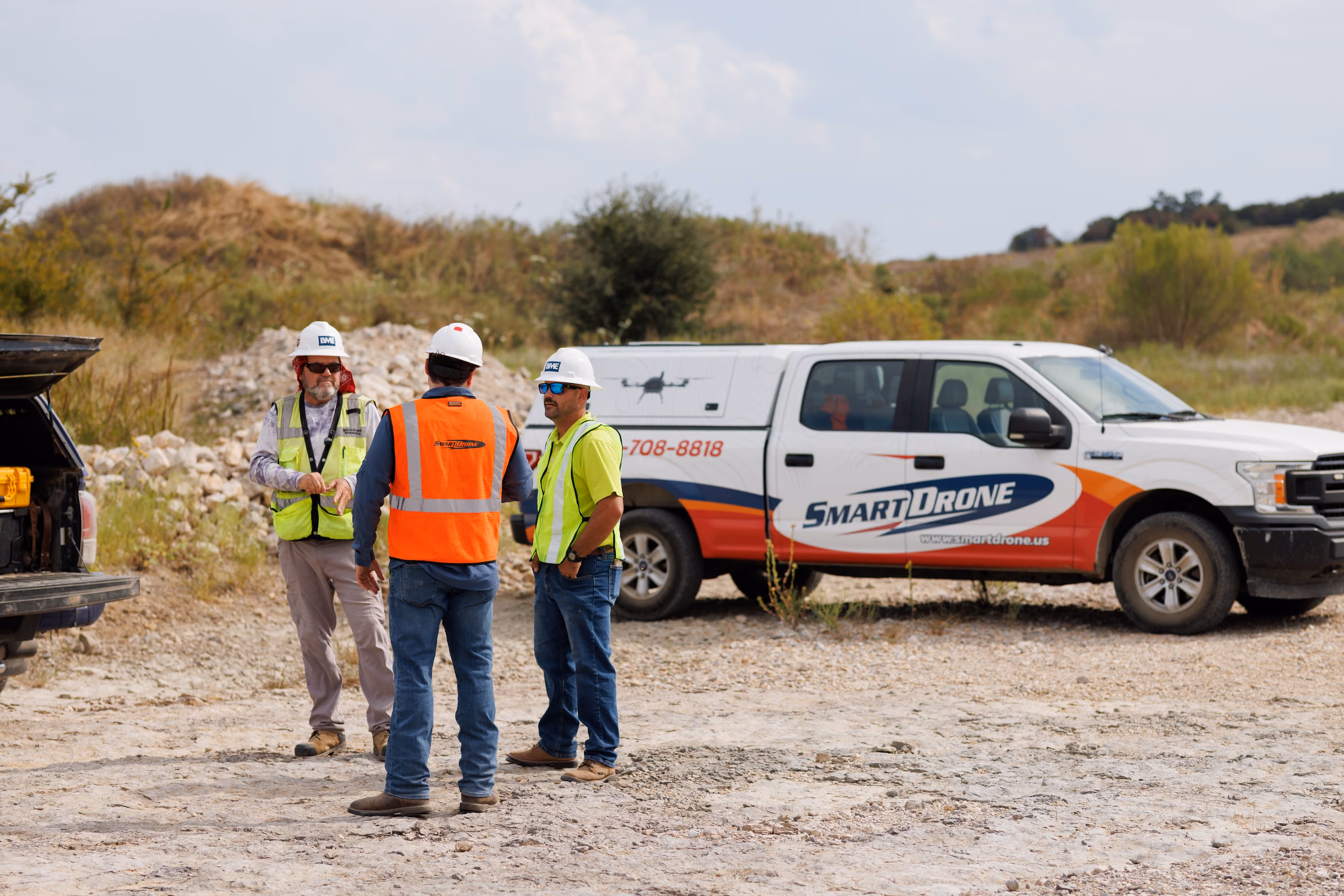 SmartDrone team member setting up the orange Magellan drone in the field.