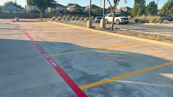 A red fire lane and yellow parking stall lines.