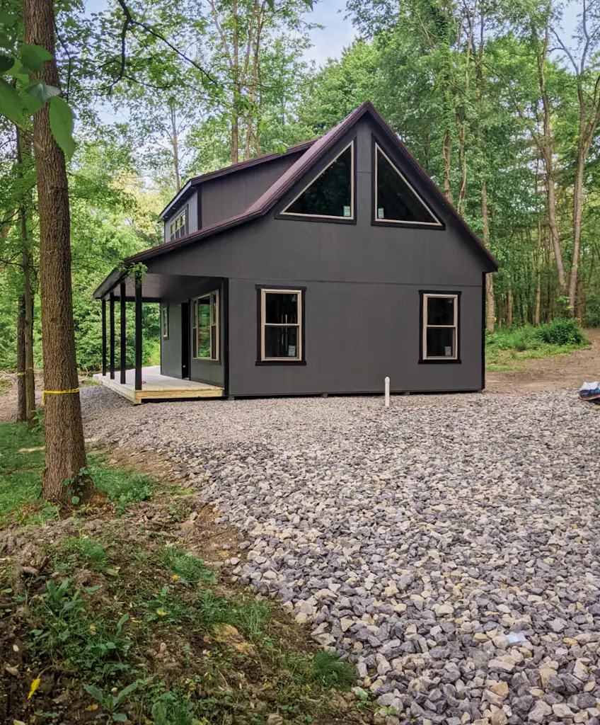 dark cabin with porch on a stone path