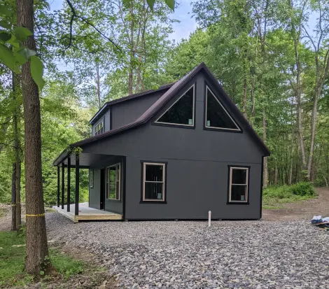 cabin with a porch and 2 stories