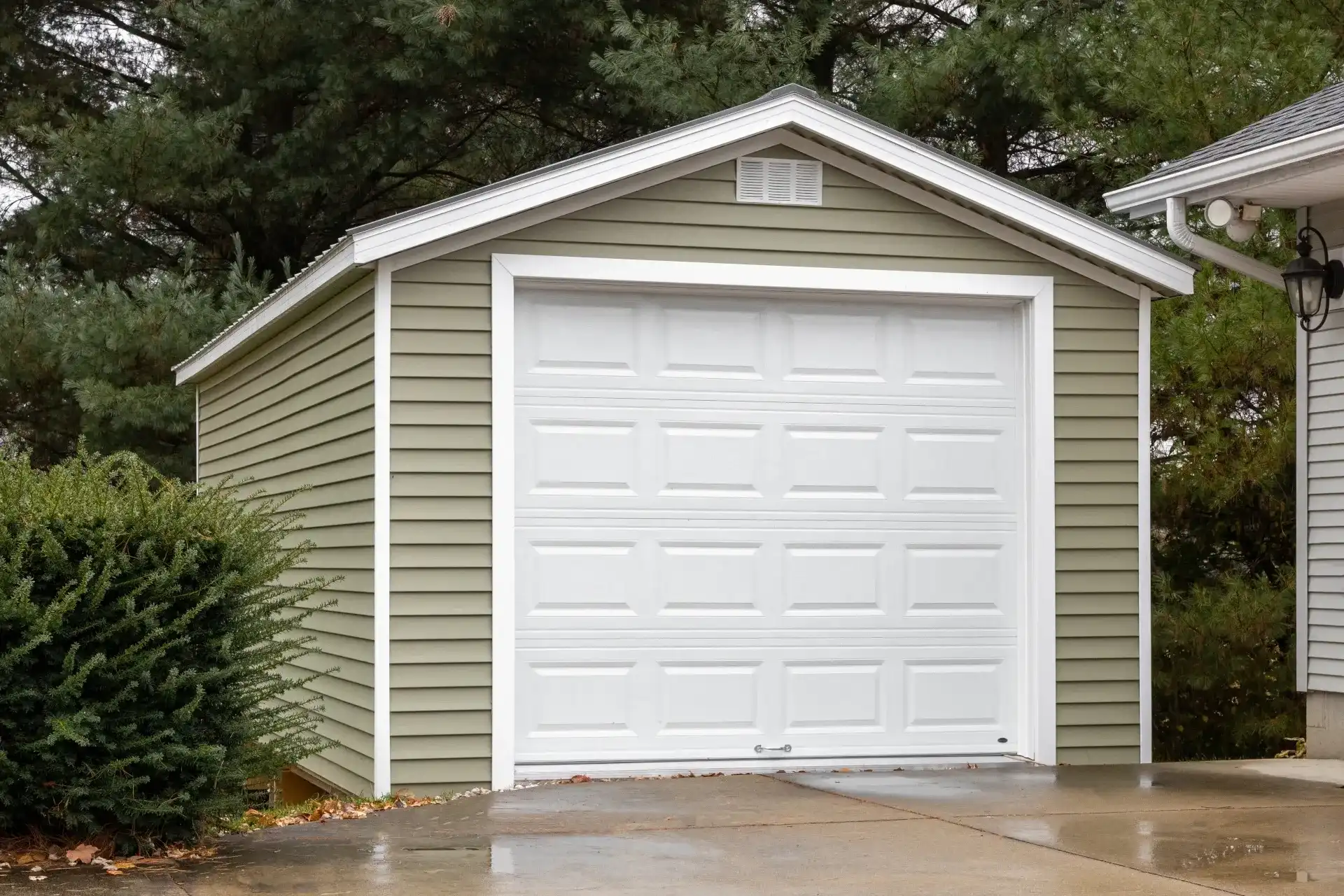 a shed with overhead door and siding compressed