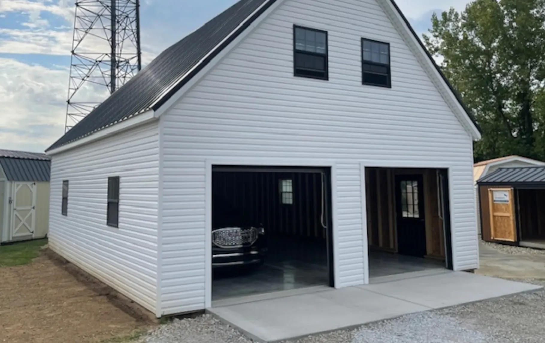 white double door garage with 2 stories and black car inside