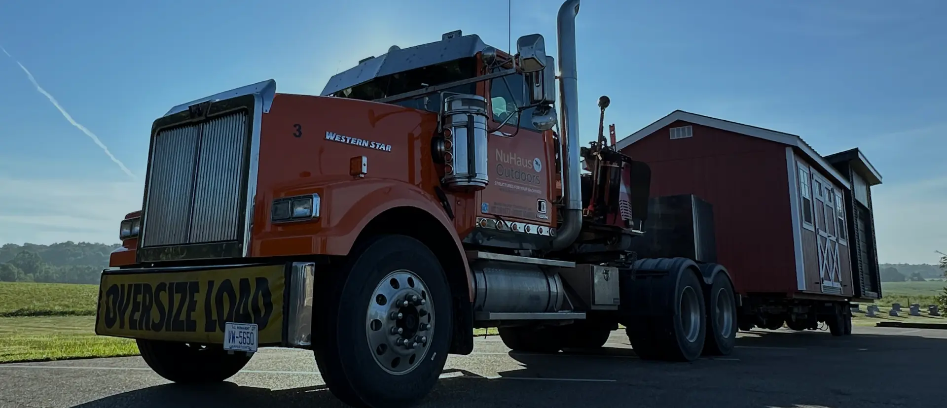 nuhaus semi truck pulling along a shed
