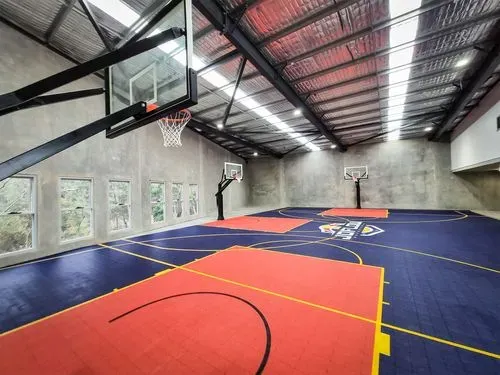 An indoor basketball court with a basketball hoop.