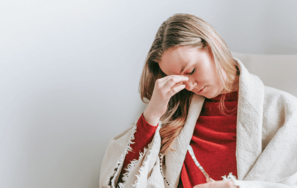 Woman closing her eyes in discomfort due to burning eyes, a common reason for visiting an optometrist. 