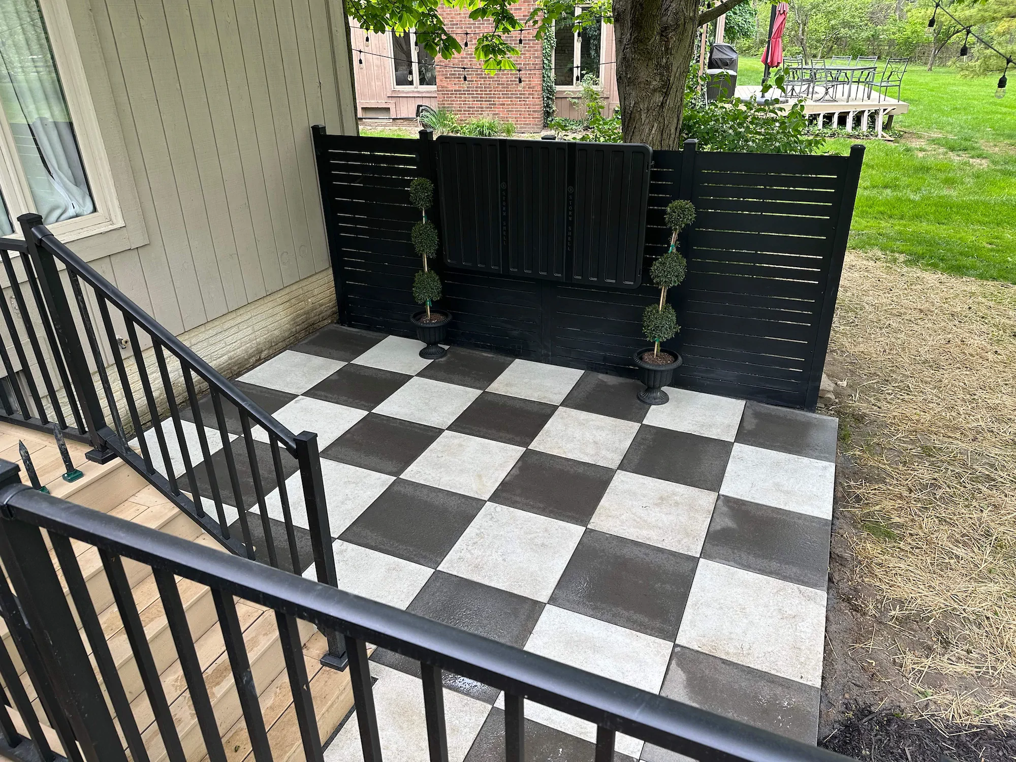 A custom patio design with black and white square tiles.