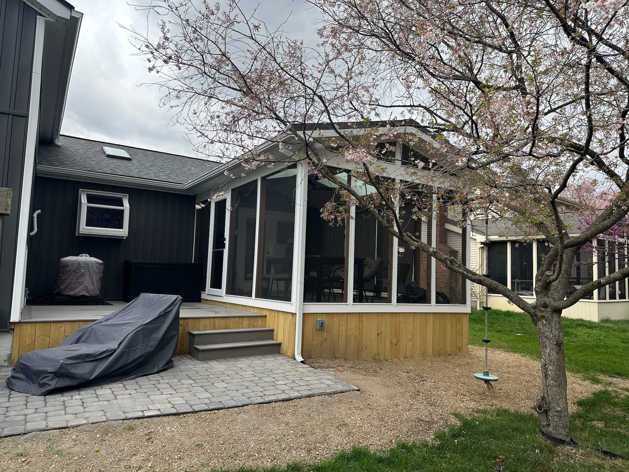 A Columbus paver patio outside an enclosed addition with a screen door for patio living in the warmer months.