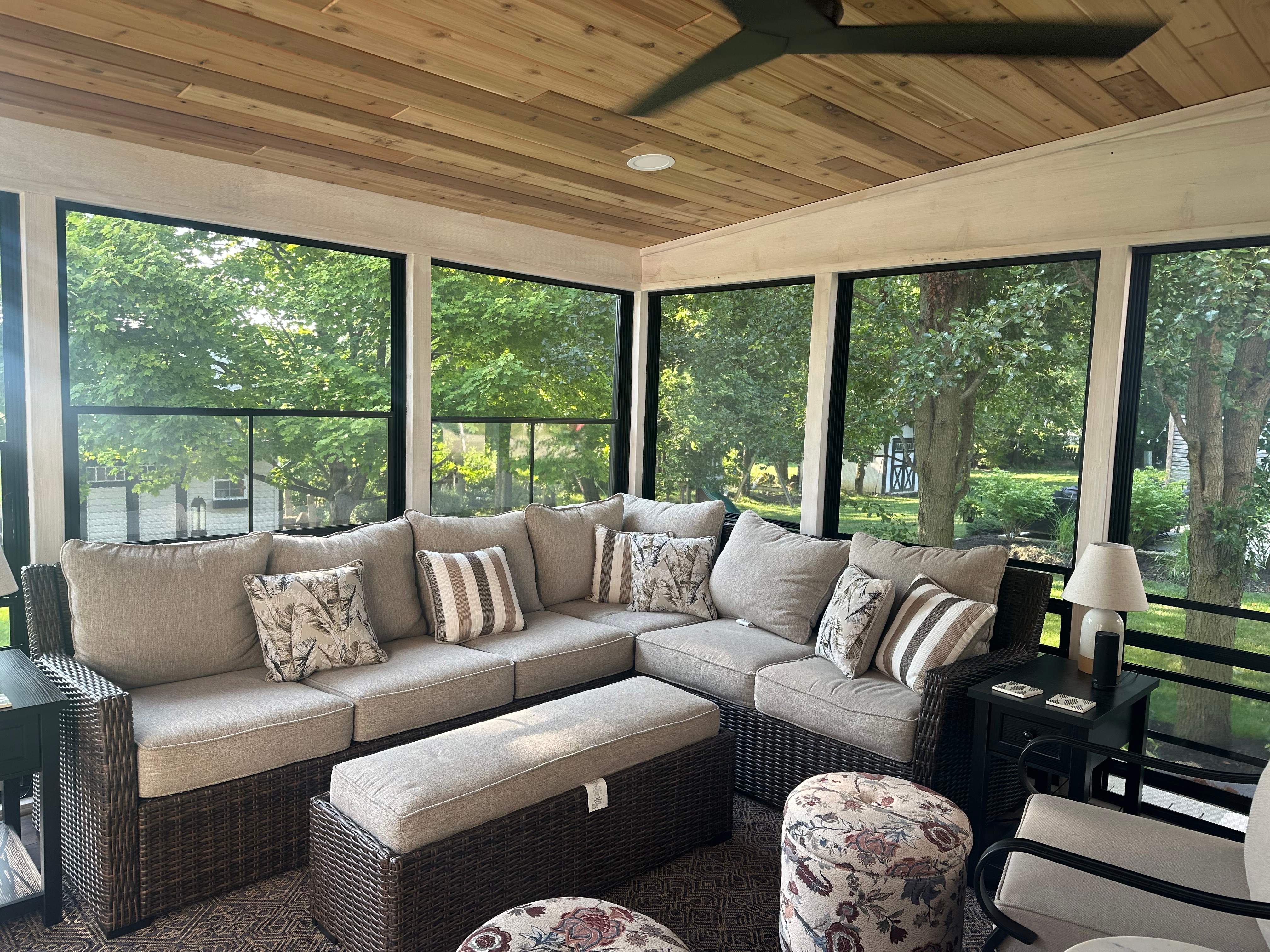 A porch with vinyl Eze-Breeze windows, furniture, and other outdoor living products.