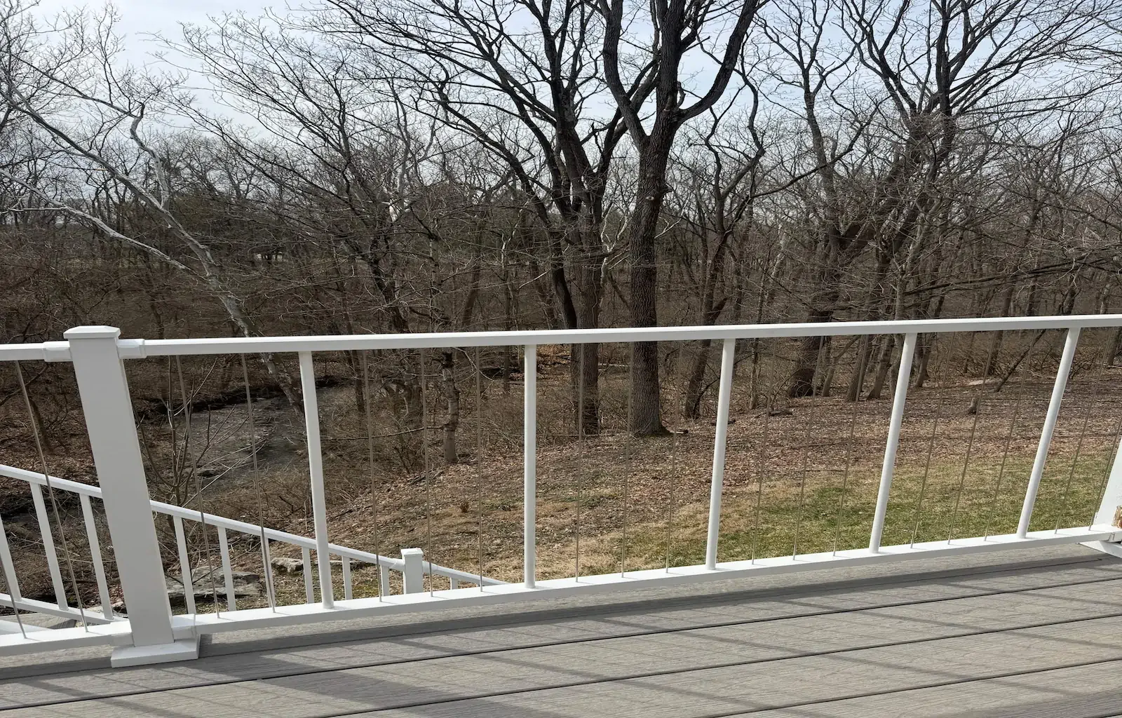 A newly installed composite back deck with white railing.