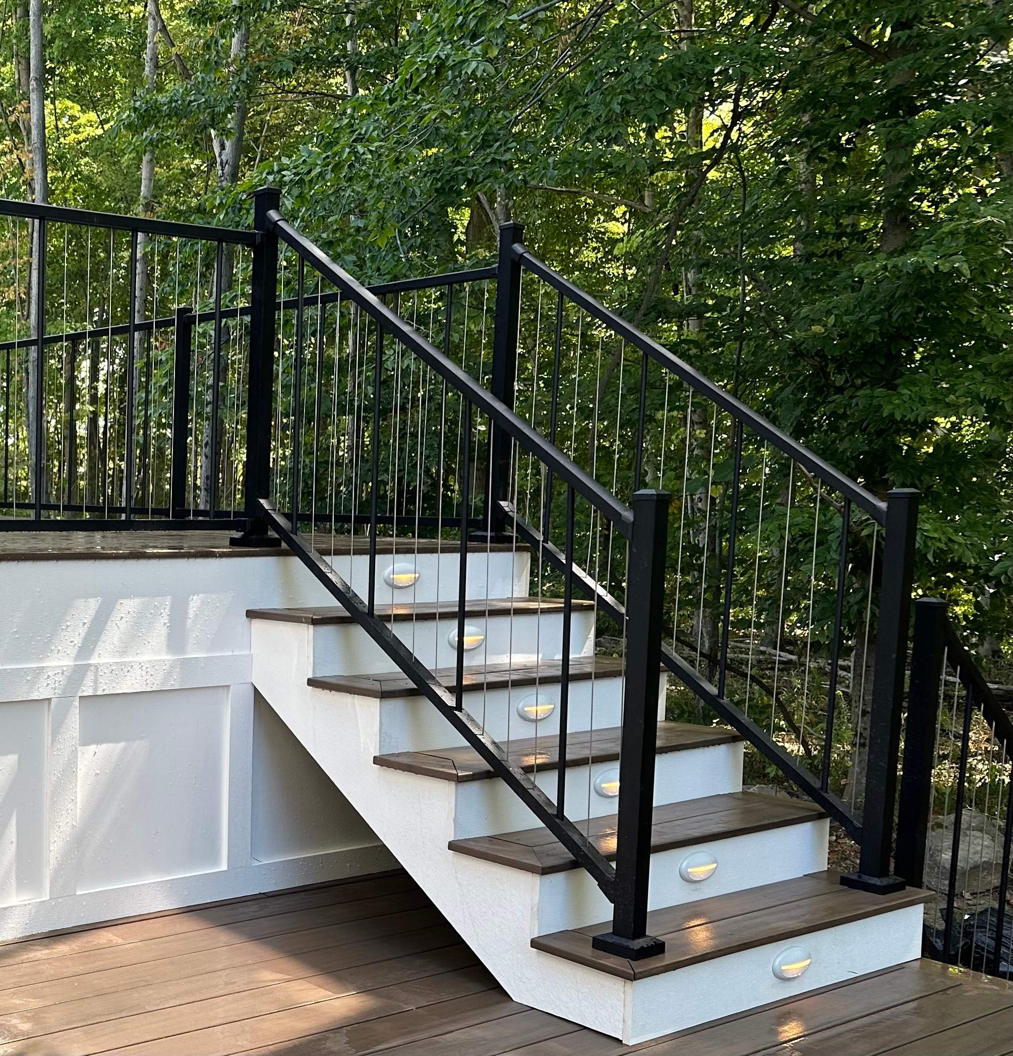 Side view of some deck steps with vertical railing.