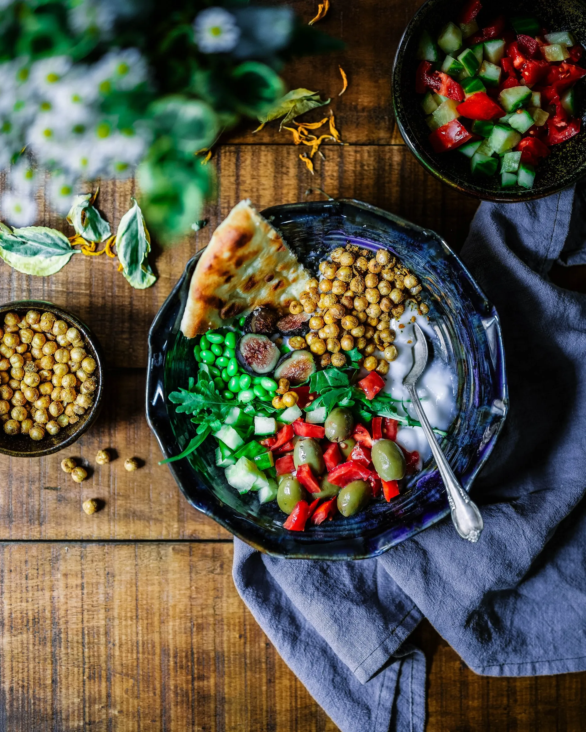 Bowl of hummus with a salad and pita bread
