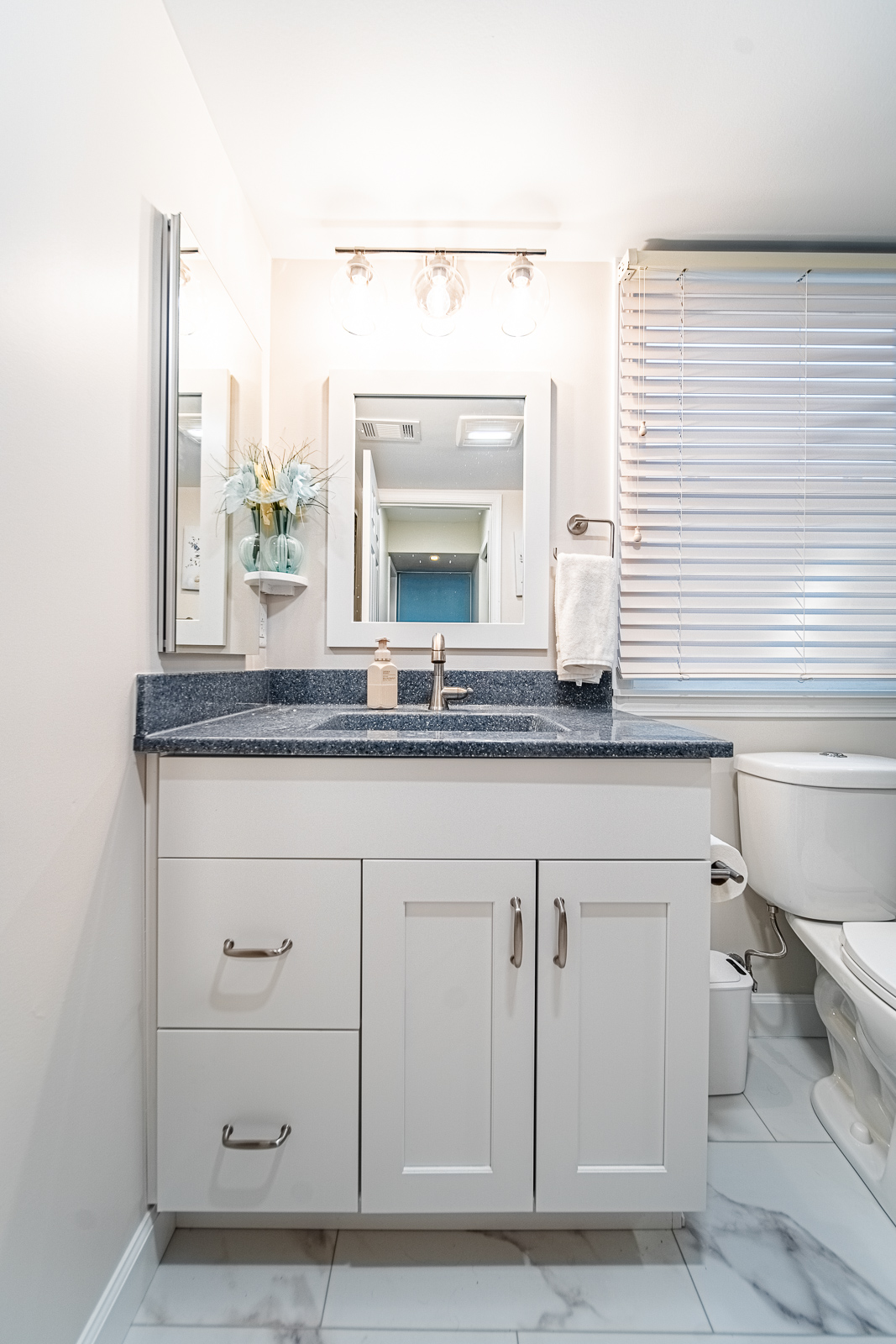 Detail of brushed nickel shower hardware and niche shelving in a custom-tiled walk-in shower in Lafayette bathroom remodel.