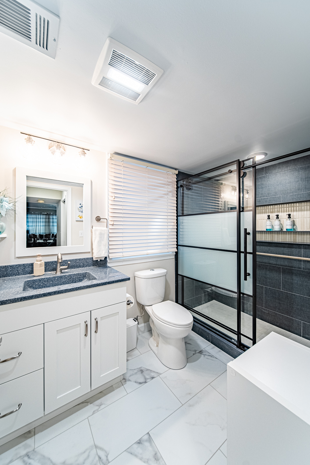 White bathroom vanity with cultured marble top, single sink, and brushed nickel faucet in remodeled Tippecanoe County basement bath