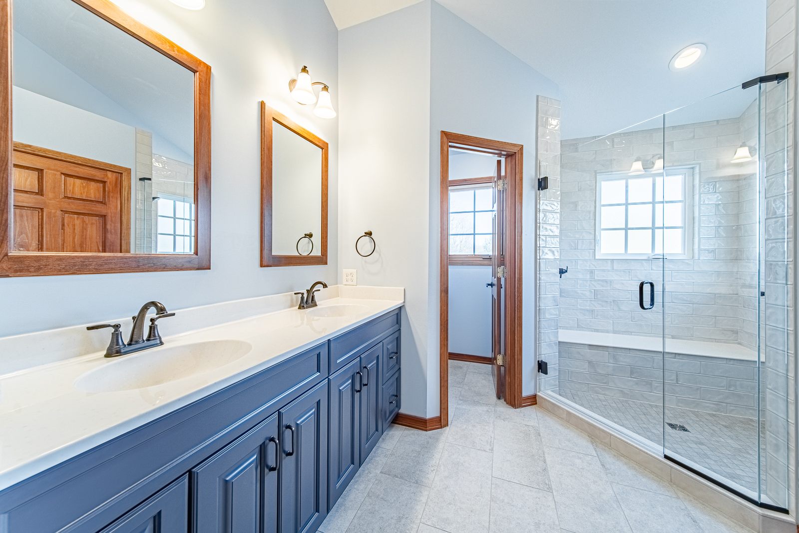 This bright, functional primary bathroom remodel in Lafayette features a custom double vanity, walk-in shower, and elegant tile finishes.